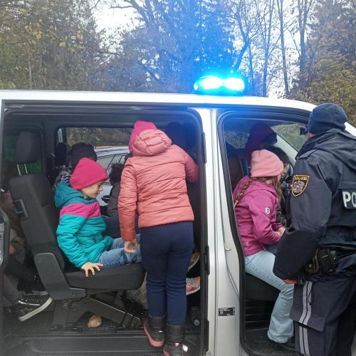 Kinder sitzen im Polizeiauto